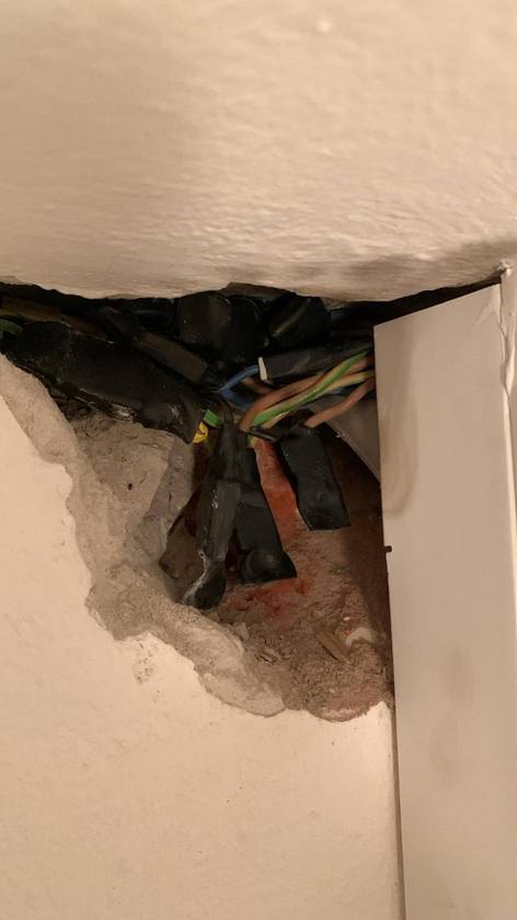 Geöffnete Wand mit freigelegter elektrischer Verbindung in Ringschnait.