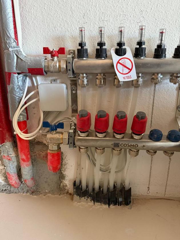 Heizkreisverteiler mit roten Stellantrieben und elektrischer Anschlussdose in Stafflangen.